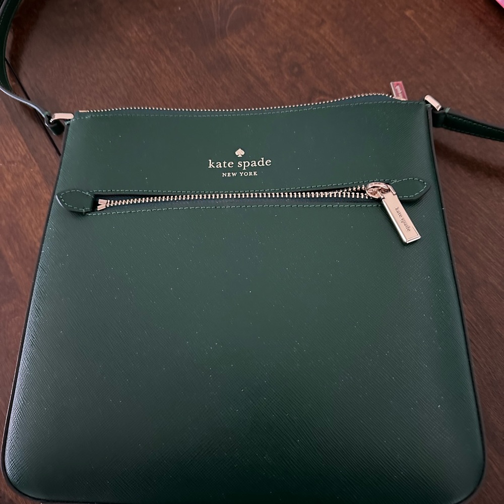 Designer leather cross body bag.    Outer zip pocket, inner zip pocket two extra